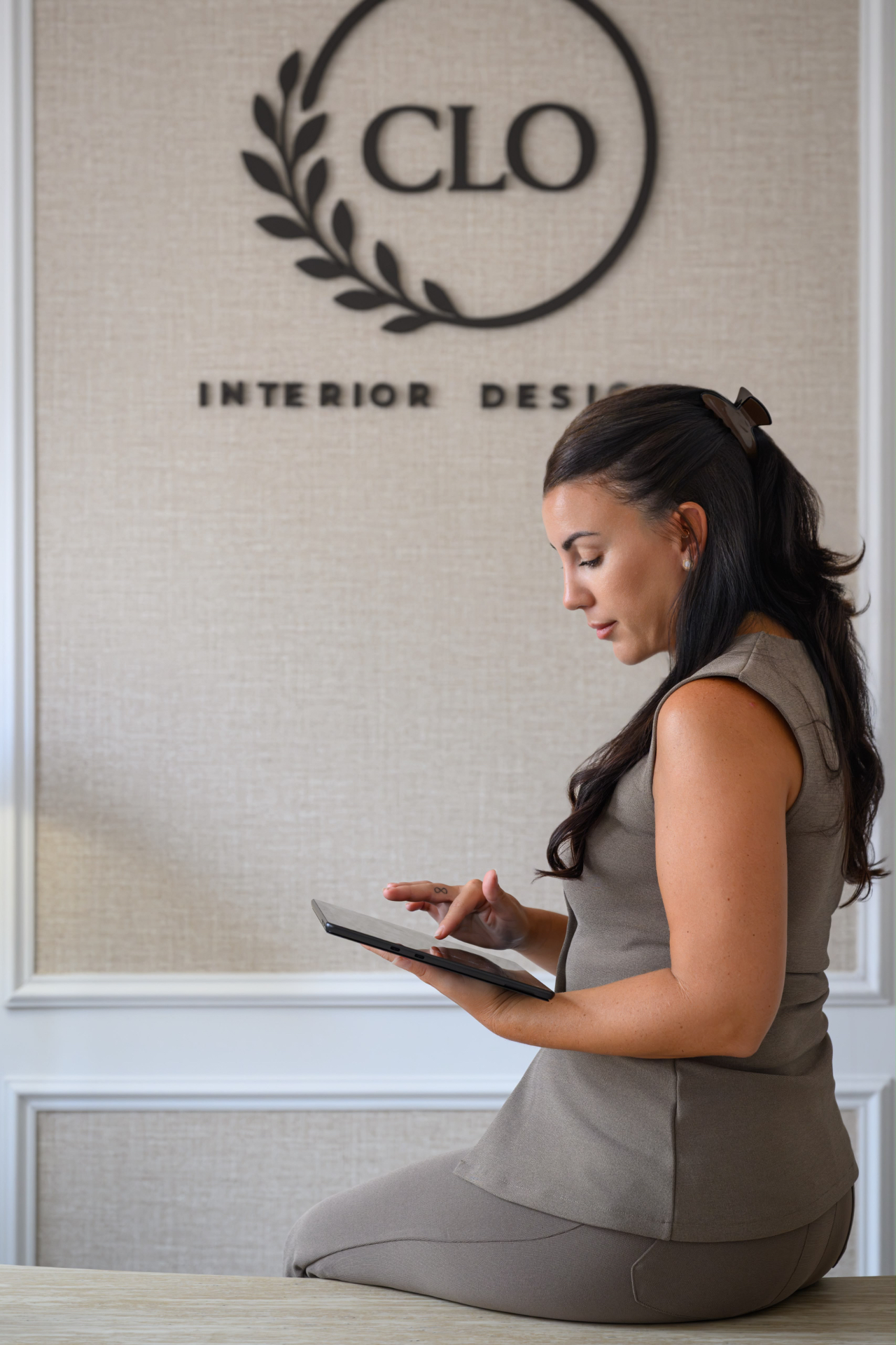 Chloe reviewing designs on a tablet in the Clo Interior Designs studio